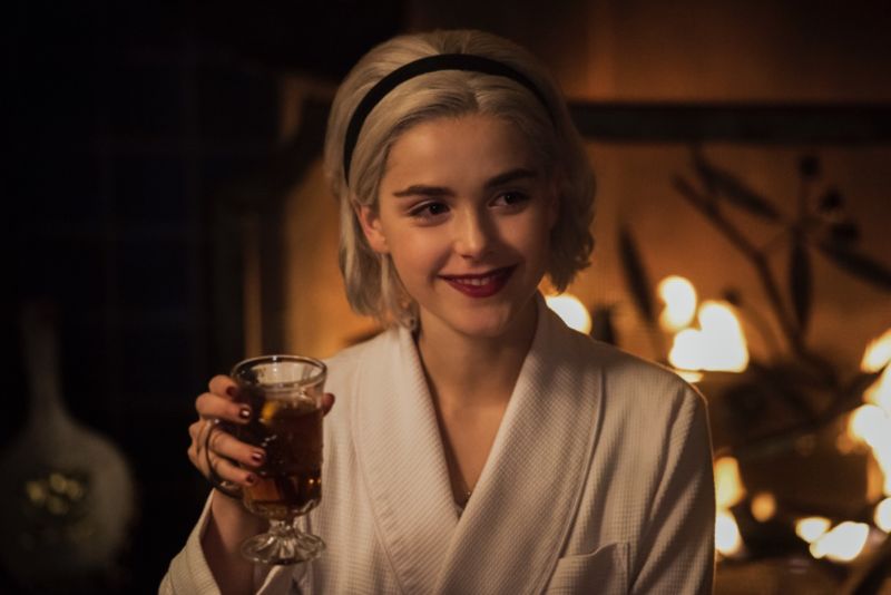 Sabrina Spellman (Kiernan Shipka) toasts friends and family at the witchy winter solstice in <em>The Chilling Adventures of Sabrina</em> holiday special.