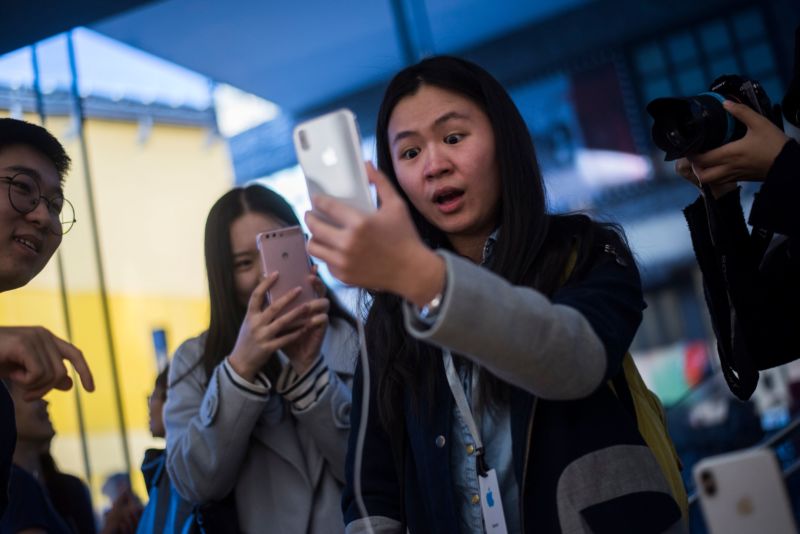 A young woman is impressed by something on her smartphone.