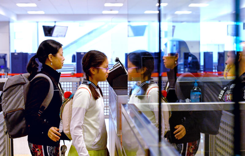 After arriving from China, Wenhong Chen and Funina Wu, from Frederick, Maryland, are photographed at Dulles as part of the US Customs and Border Protection's newly implemented biometrics system.