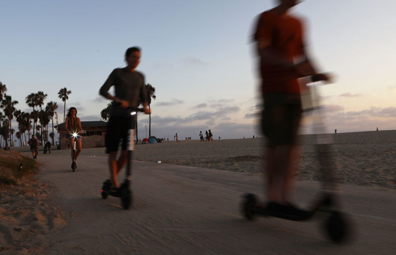 People ride shared dockless electric scooters along Venice Beach on August 13, 2018 in Los Angeles, California. 