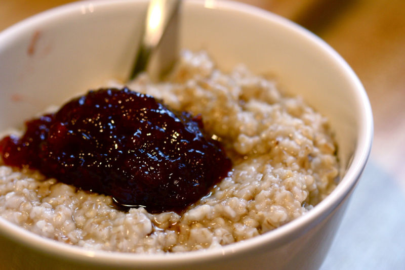 Close-up photo of a bowl of oatmeal topped with fruit preserves.