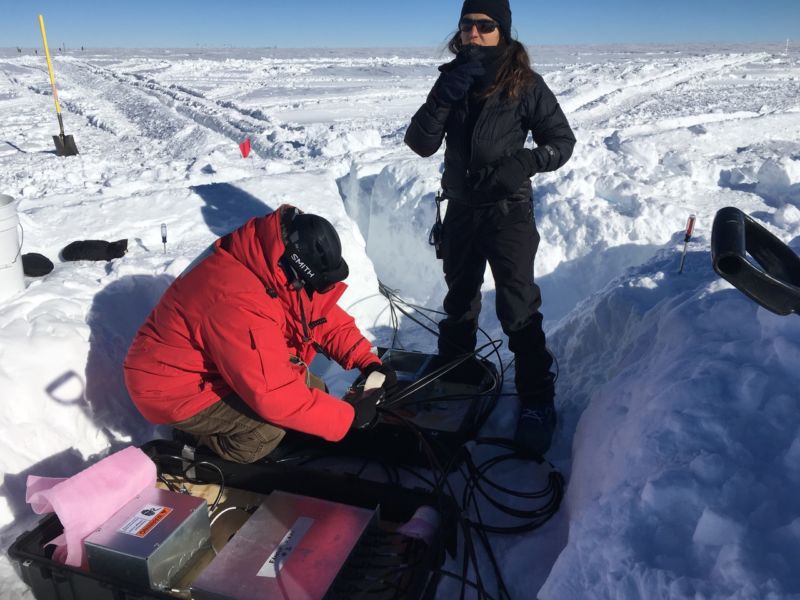 Image of people working on electronics in a snow trench.