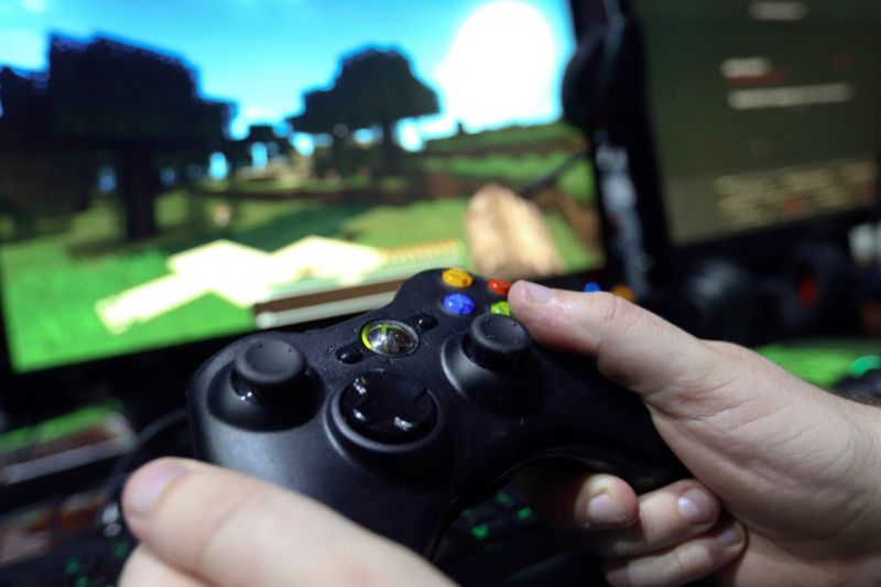 A visitor holds a hand control unit to play <em>Minecraft </em>during the EGX gaming conference in London, September 2014.