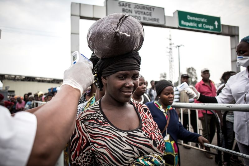 A woman gets her temperature measured at an Ebola screening station as she enters Rwanda from the Democratic Republic of the Congo on July 16, 2019 in Goma. 