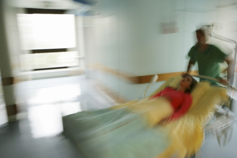 Stylized photograph of a woman in a hospital bed.