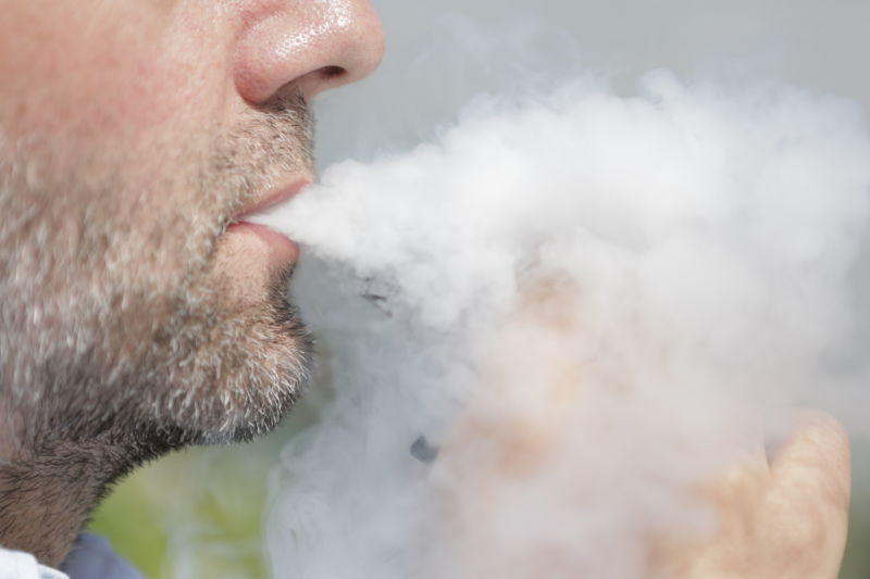 A man smokes an e-cigarette.