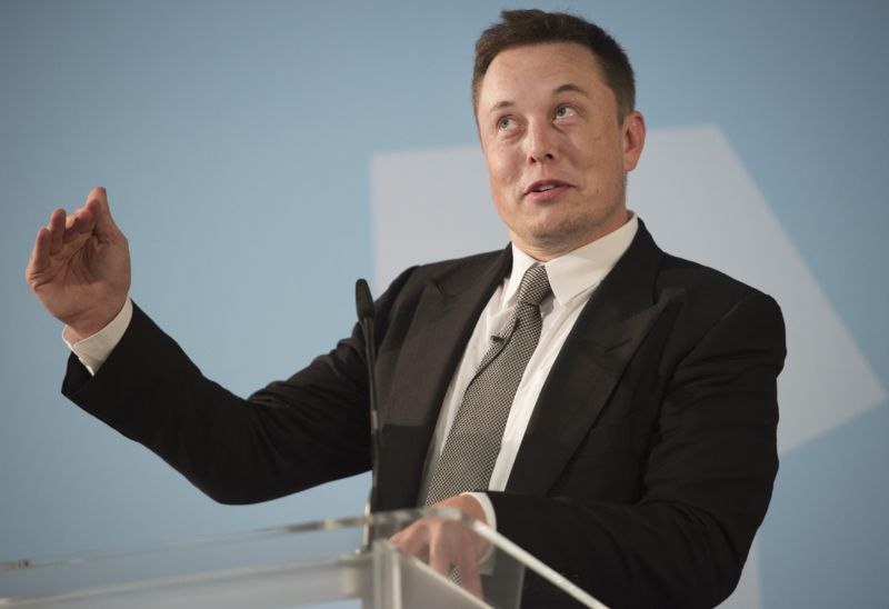 A man in a suit speaks at a podium.