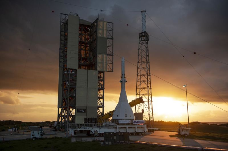 A rocket sits on a launch pad at dawn.