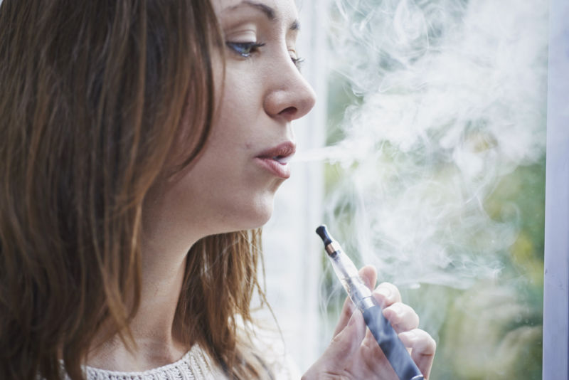 Woman smoking electronic cigarette.