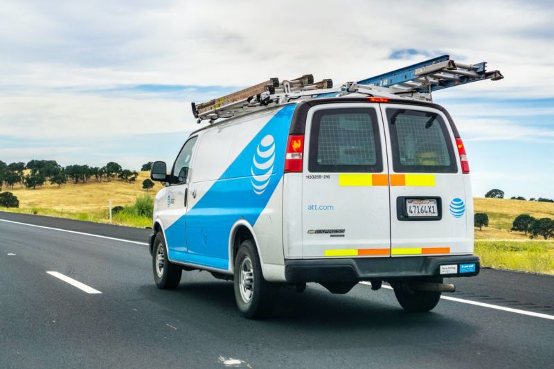 An AT&T service van driving on a freeway.