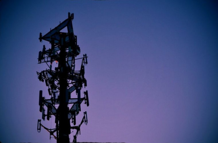 A cell phone tower at dusk.