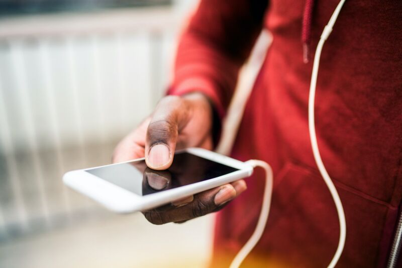 A man's hand holding a smartphone.