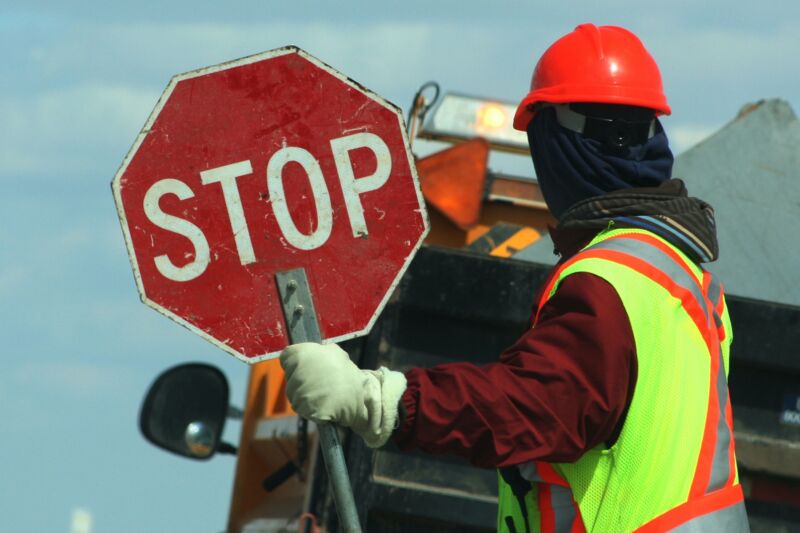 A construction worker holding a stop sign.