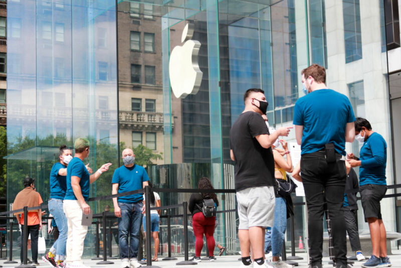 NEW YORK, June 17, 2020 -- Staff workers serve customers outside an Apple store on Fifth Avenue of New York City, the United States, June 17, 2020. 