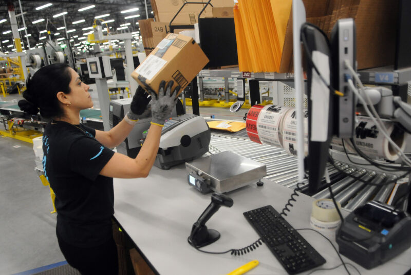 A uniformed woman lifts a small parcel.