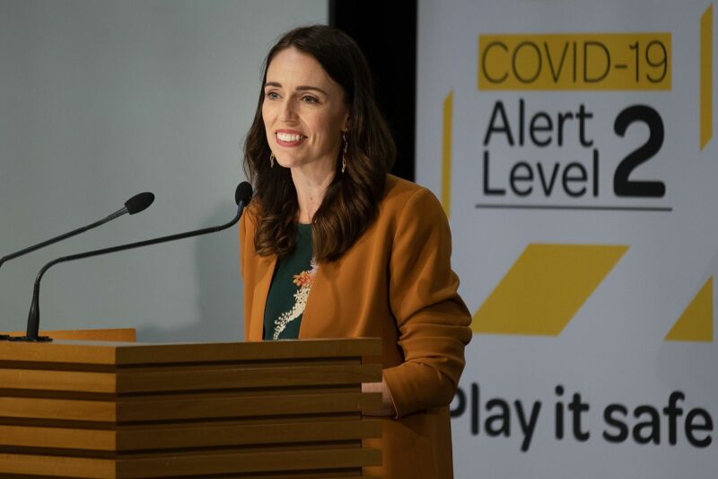 A happy woman speaks at a podium.