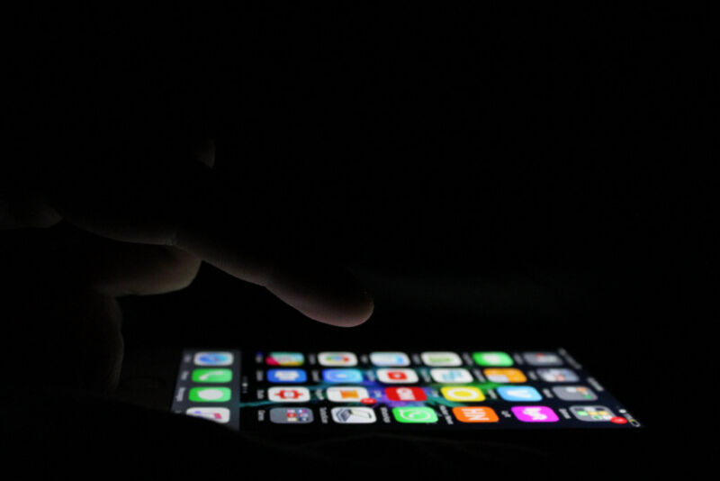 Stock photograph of a smartphone being used in the dark.