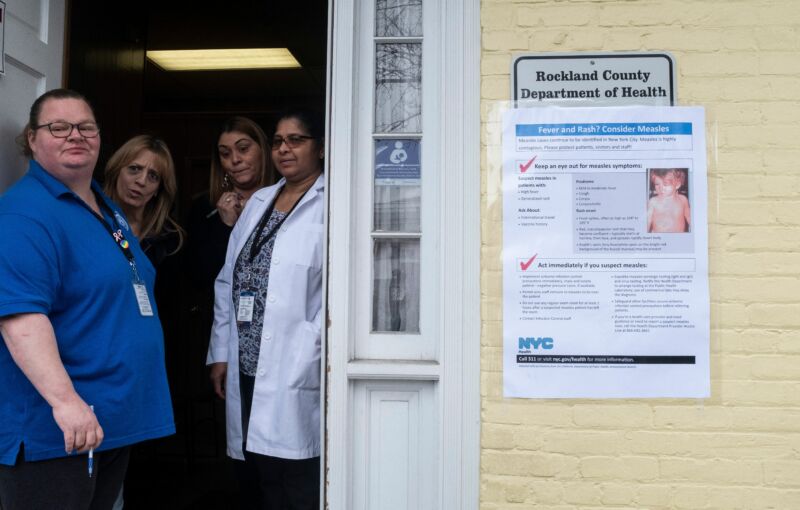 Women stand in a doorway.