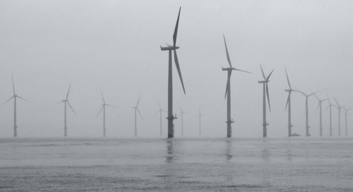 Offshore wind farm against a gray sky.