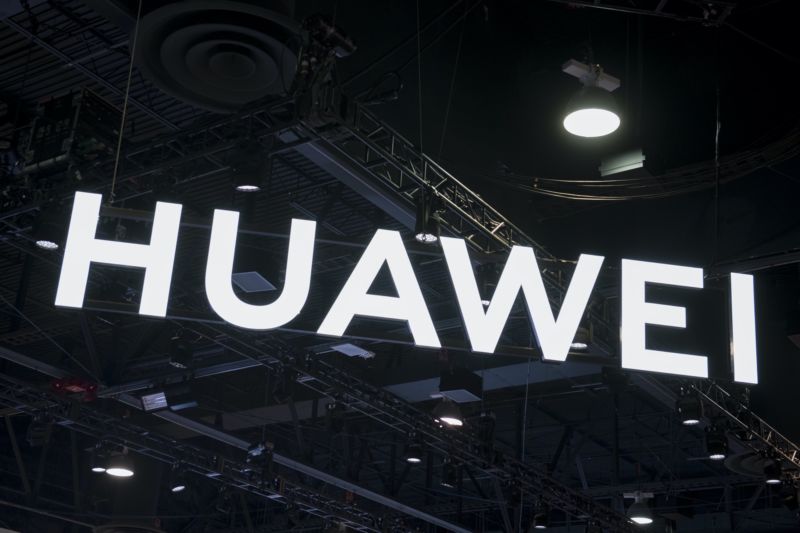 A Huawei sign hanging from the ceiling in a conference expo hall.