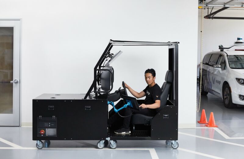 A man operates an automobile simulator.