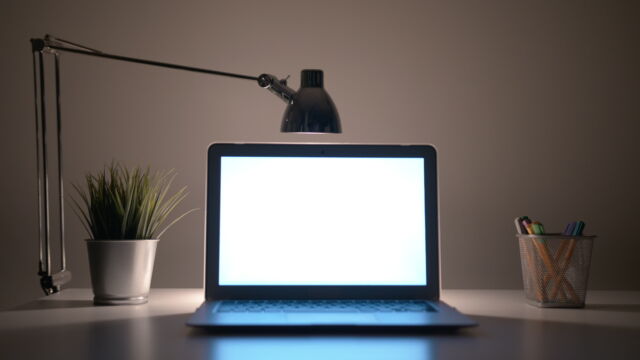 You definitely want that light <em>behind</em> your screen, not aimed at it. A bit of illumination behind and around the screen helps reduce eyestrain.