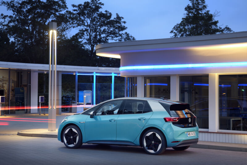 A turquoise Volkswagen ID.3 at dusk, surrounded by neon lights.