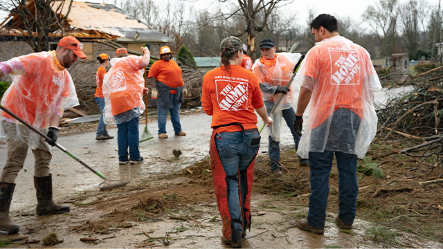 people in home depot shirts working to clean up after a natural disaster