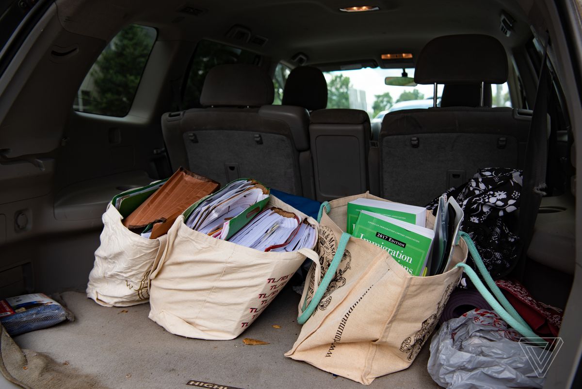 large bags of files and papers take up much of the trunk of a car.