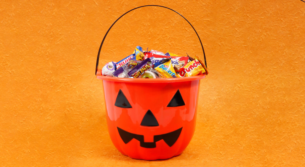 a plastic pumpkin with candy bars in it