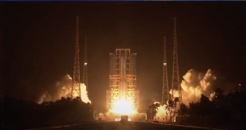 Image of a rocket with engines igniting on the launch pad.