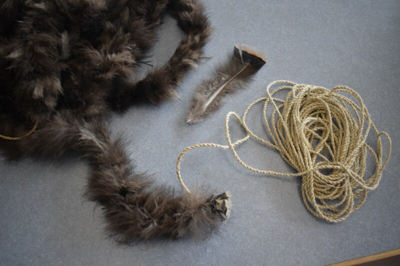 A fluffy gray blanket next to a coil of cord.