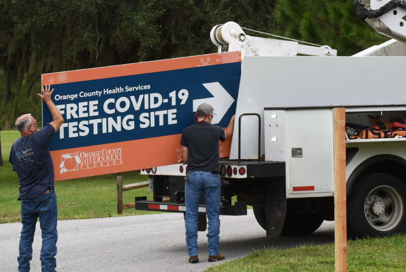 Workers removing a sign from a drive-through COVID-19 testing site in Orlando, Florida, in October 2020.