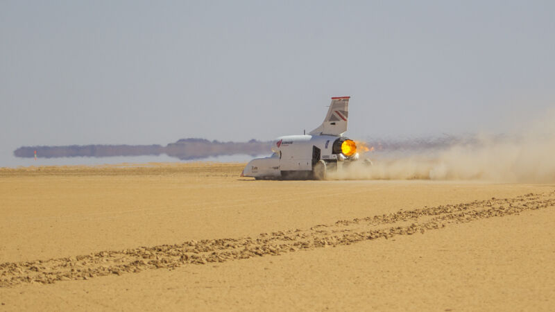 A rocket-propelled car screams across the desert.