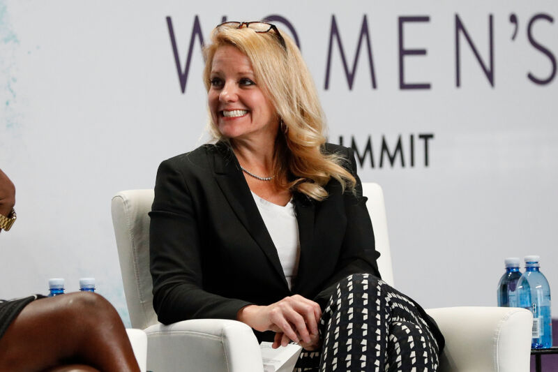 A smiling woman is seated onstage.