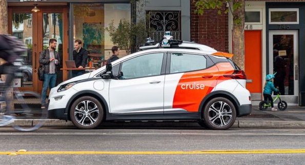 A white and red self-driving car parked on a street in San Francisco