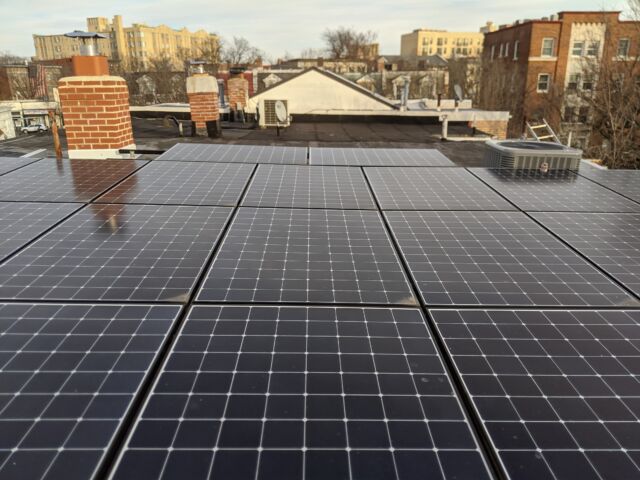 My roof has 8.5 kW of solar panels on it. In the background you can see our rebuilt chimney and the condensing unit for the heat pump.