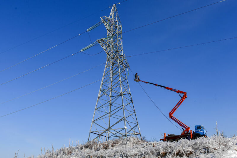 A powerline tower in a grassy field.