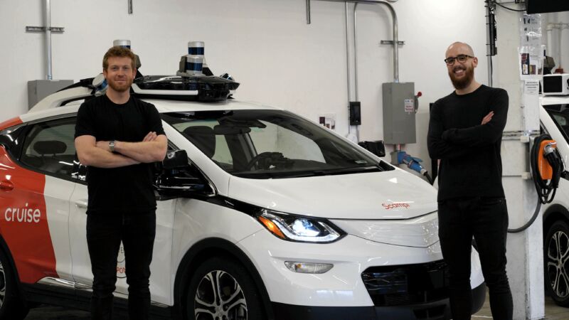 Promotional image of two men standing next to an electric car.