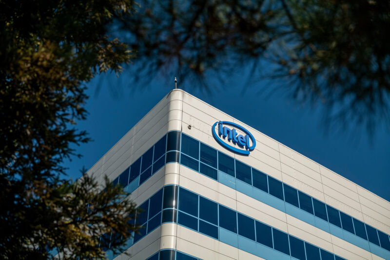 A multistory building with an Intel logo on the wall of its top floor.