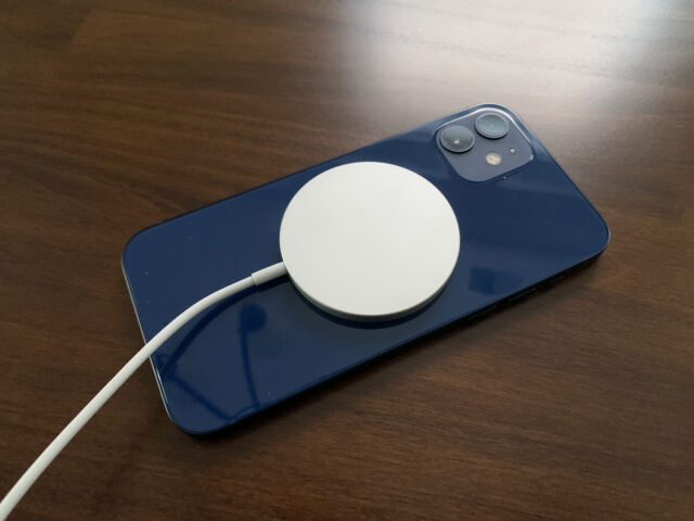 The Apple MagSafe charger attached to an iPhone 12.