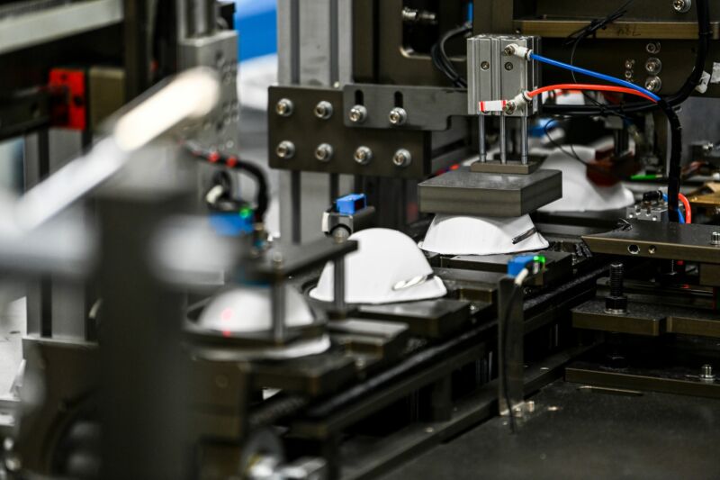 Medical masks move along a conveyor belt.