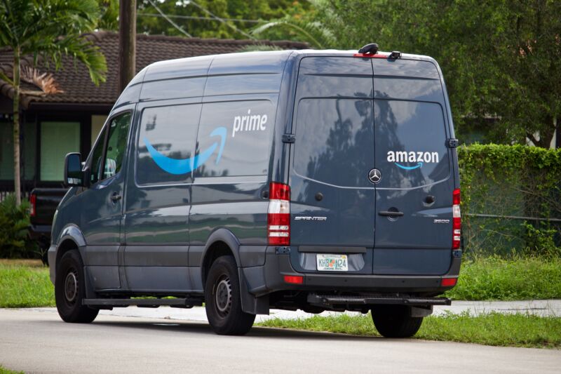 A dark blue van with multiple Amazon logos.