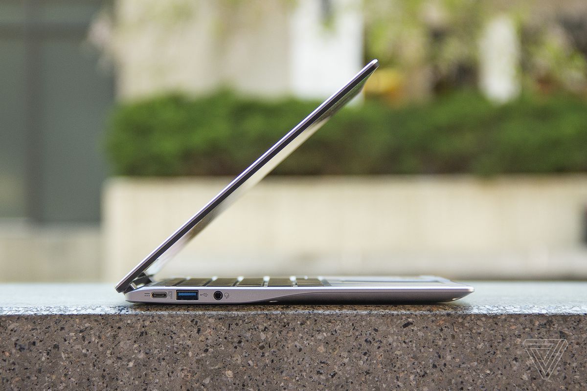 The Acer Chromebook Spin 513 on a stone bench, half open, seen from the left side.