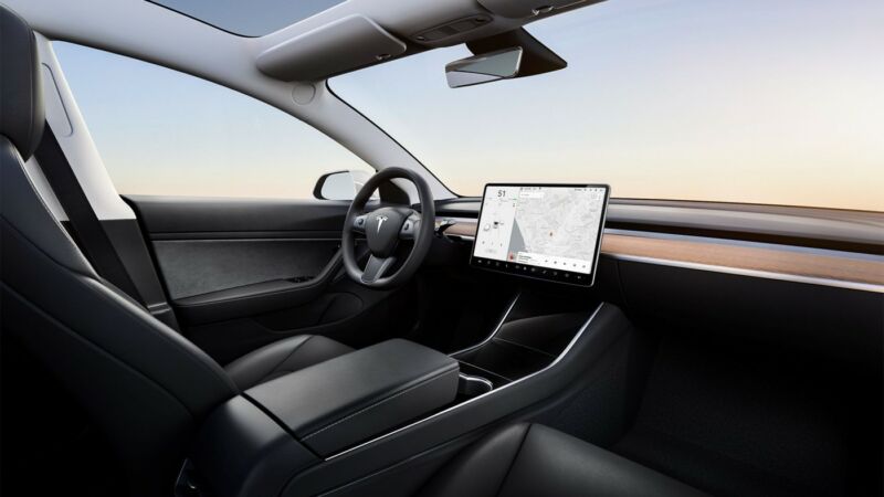 Interior of a Tesla Model 3, with a mounted device showing an area map and directions.