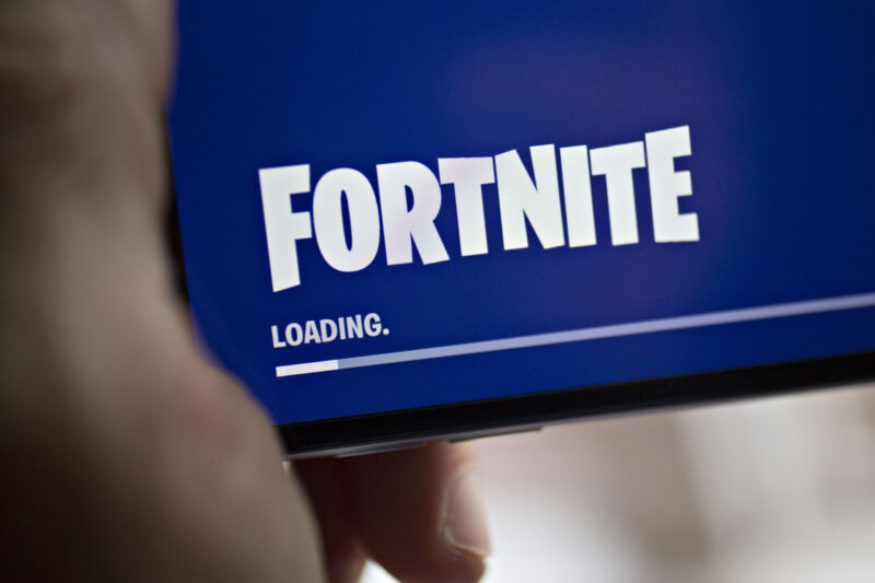 A <em>Fortnite</em> loading screen displayed on an iPhone in 2018, when Apple and Epic <em>weren’t</em> at each other’s legal throats.”><figcaption class=