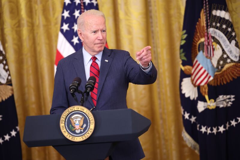 President Joe Biden standing at a dais and pointing as he speaks at a press conference.