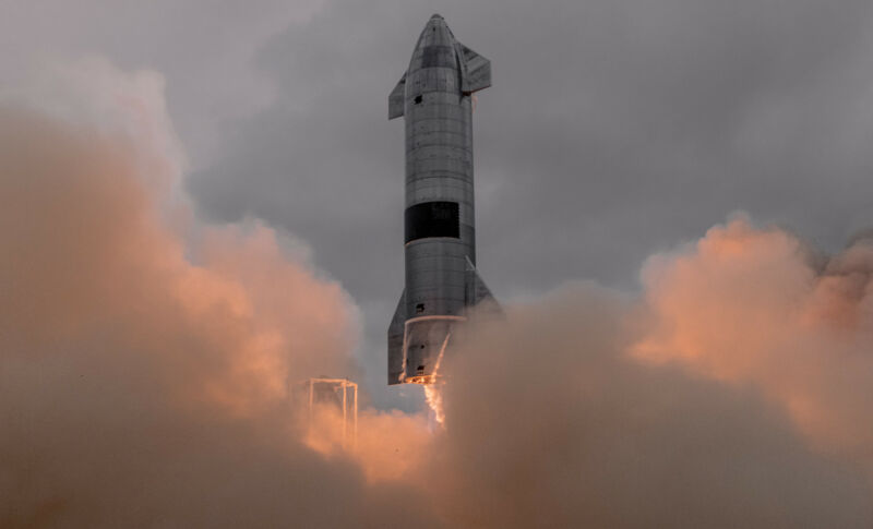 Smoke and flame surround a squat rocket as it lifts off.