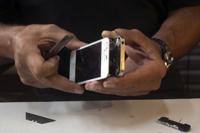 Michael Ghadieh, owner of FixMyPhoneSF, fixes an Apple Inc. iPhone in his shop in San Francisco, California, U.S., on Friday, Aug. 23, 2013. Photographer: David Paul Morris/Bloomberg *** Local Caption *** Michael Ghadieh