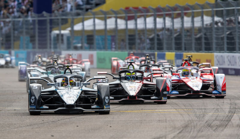 A group of Formula E cars race towards the camera